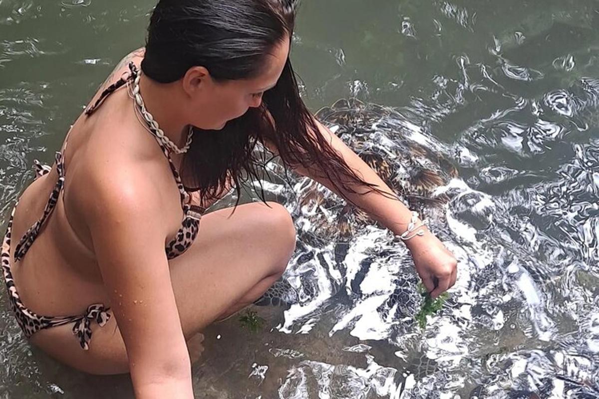 una donna in bikini seduta in acqua con un aigatore