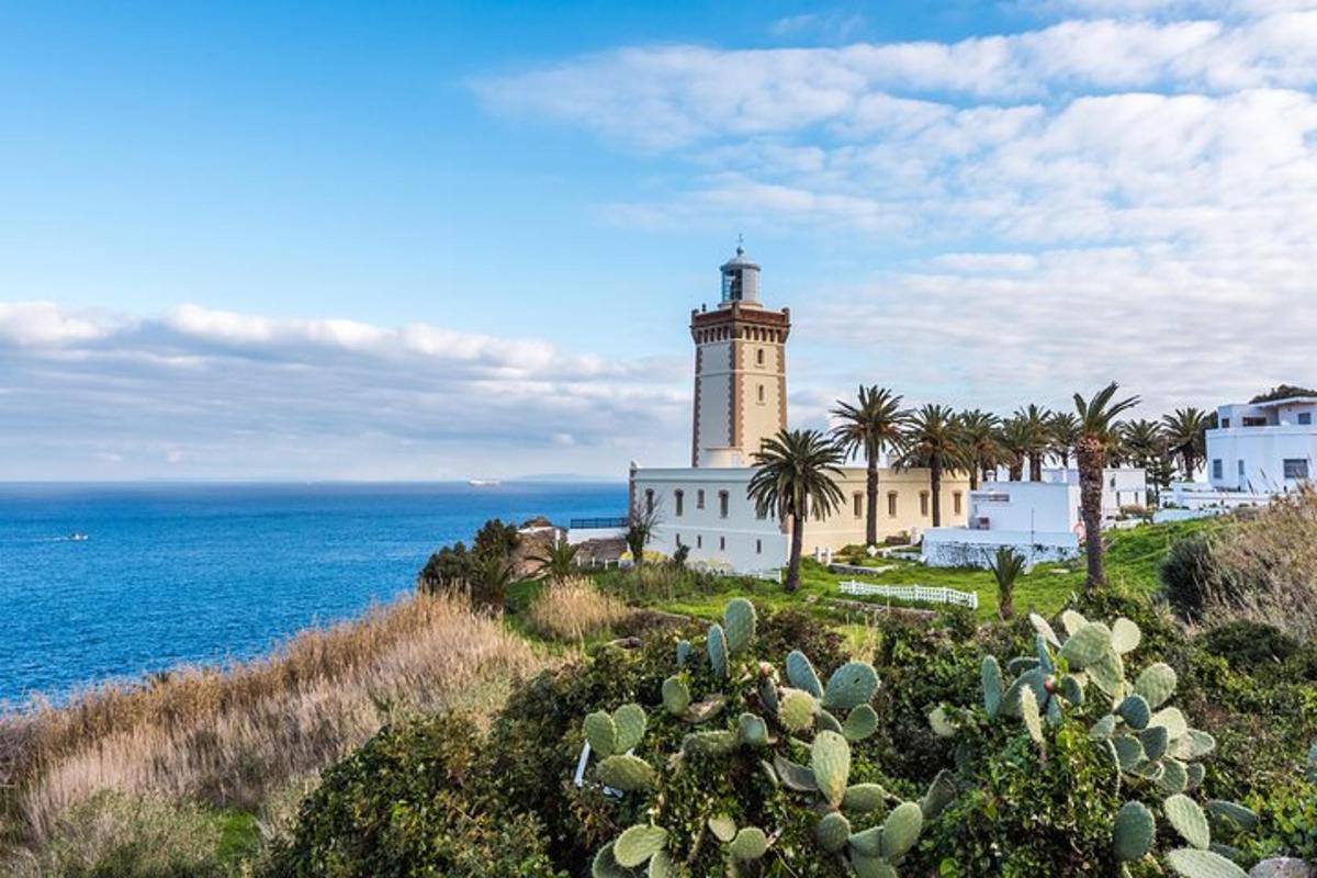 un faro in cima a una collina vicino all'oceano