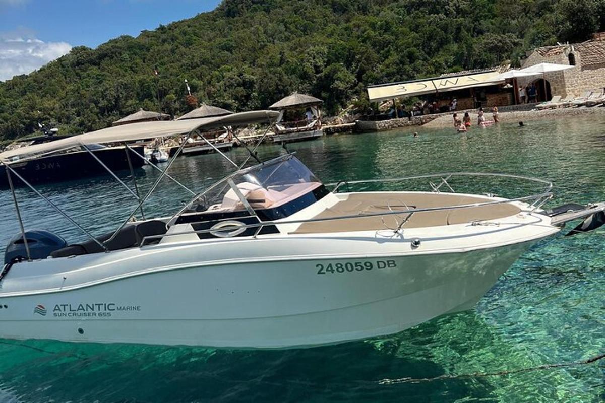 um barco branco na água perto de uma praia