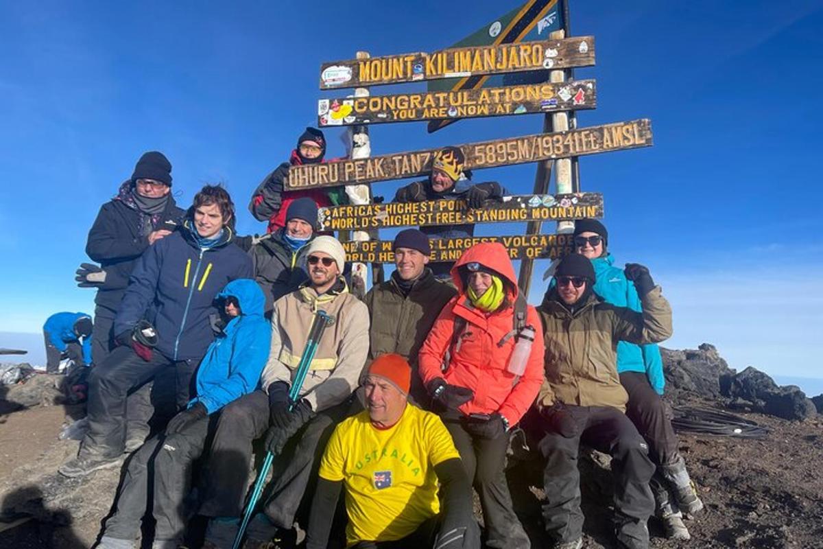 grupp inimesi poseerib mäe tipus pildi jaoks