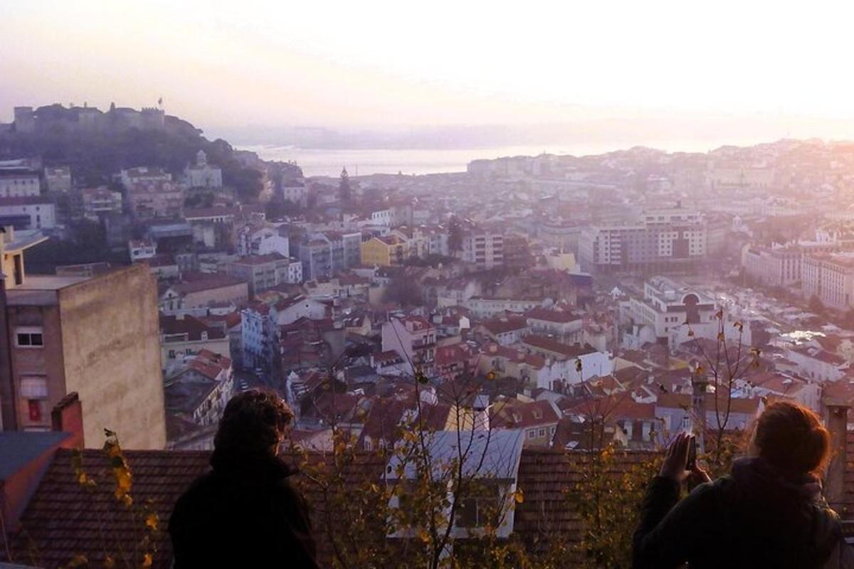 Zwei Menschen stehen auf einer Mauer und blicken auf eine Stadt