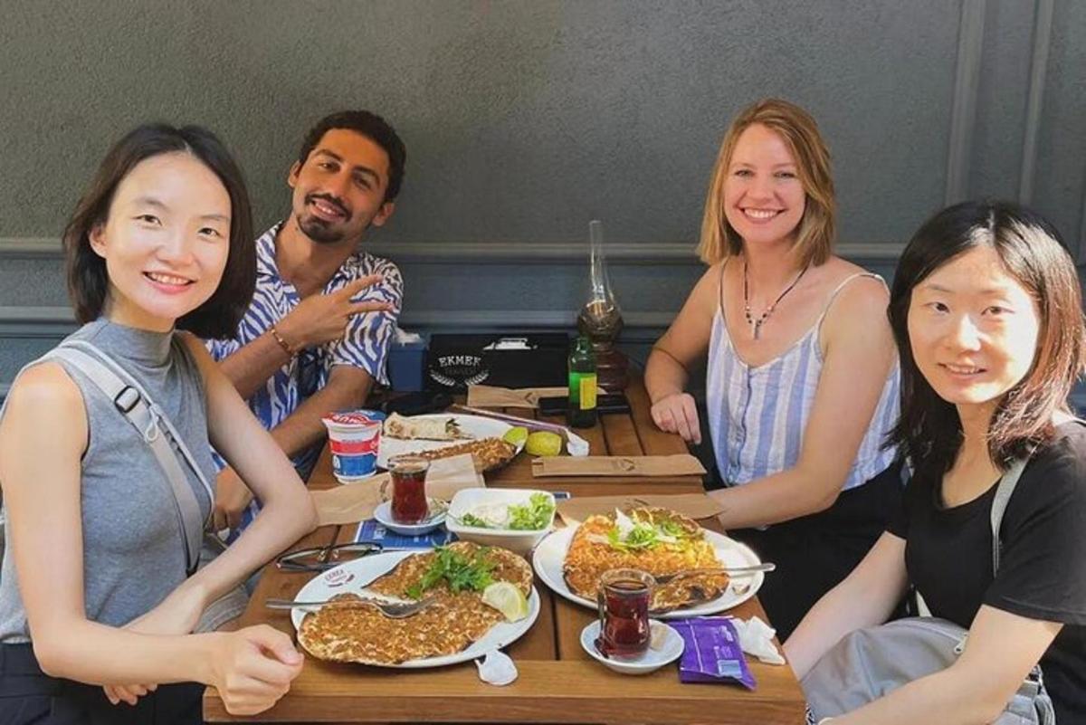 um grupo de pessoas sentadas ao redor de uma mesa com comida