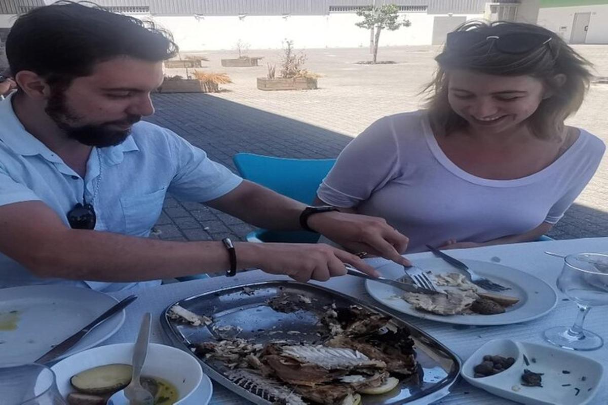 moški in ženska sedita za mizo in jesta hrano
