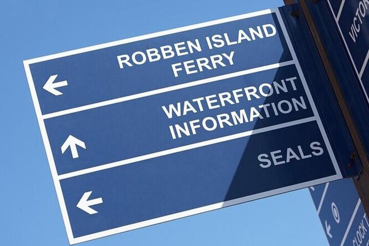 un rètol de carrer blau amb les paraules Ribbon Island Ferry i segells d'informació sobre el passeig marítim