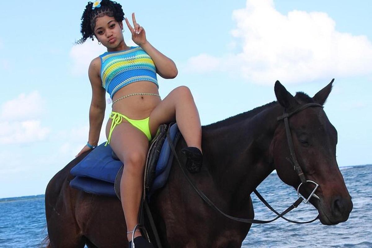 a young woman riding a horse on the beach