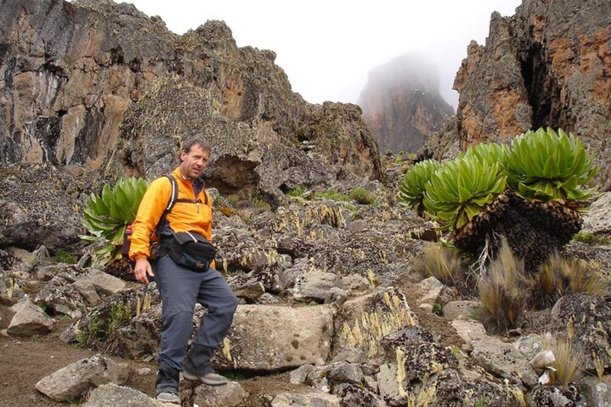 un uomo in piedi su una montagna rocciosa con delle banane
