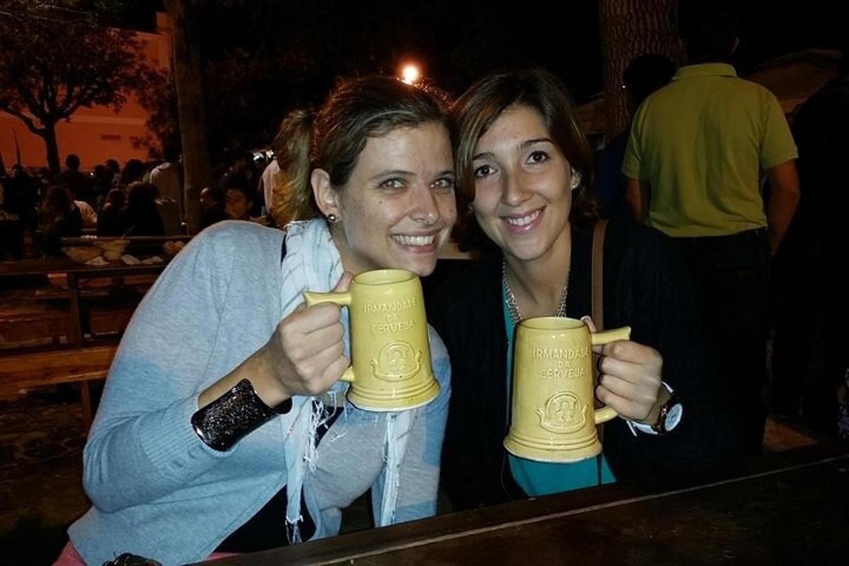 due persone che tengono in mano due boccali di birra