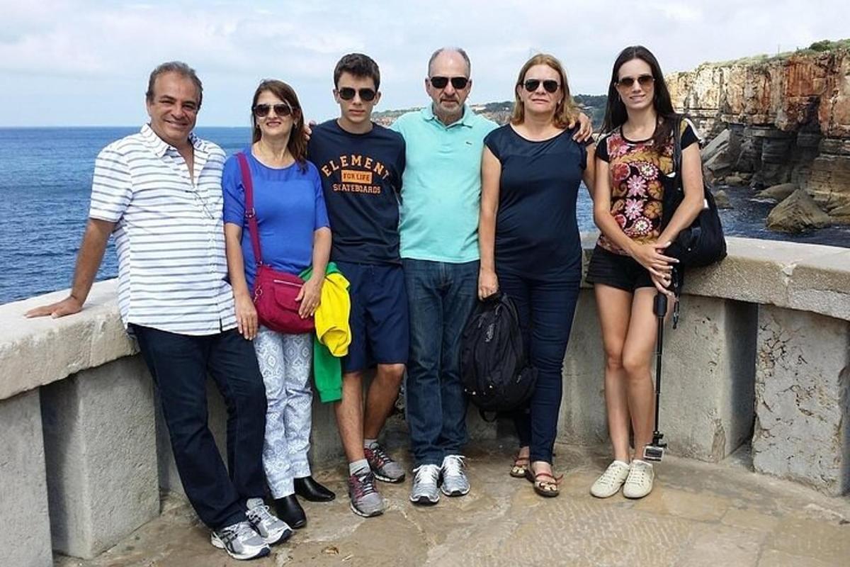 un gruppo di persone in piedi su un muro vicino all'oceano