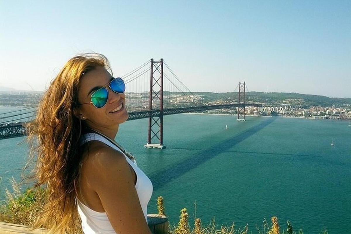 una donna con occhiali da sole in piedi davanti a un ponte