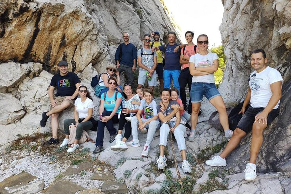 cilvēku grupa pozē fotografēšanai uz klintīm