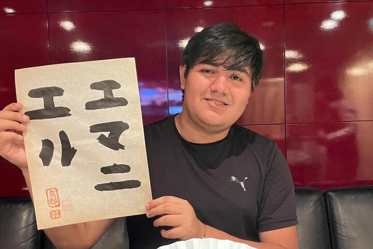 Muž drží ceduli s japonskými písmeny