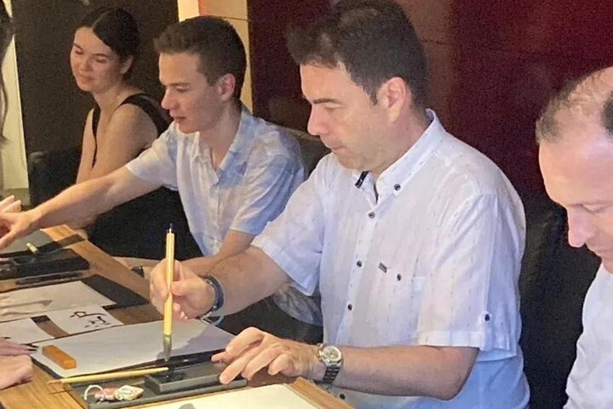 skupina mužov stojacich okolo stola so zariadením