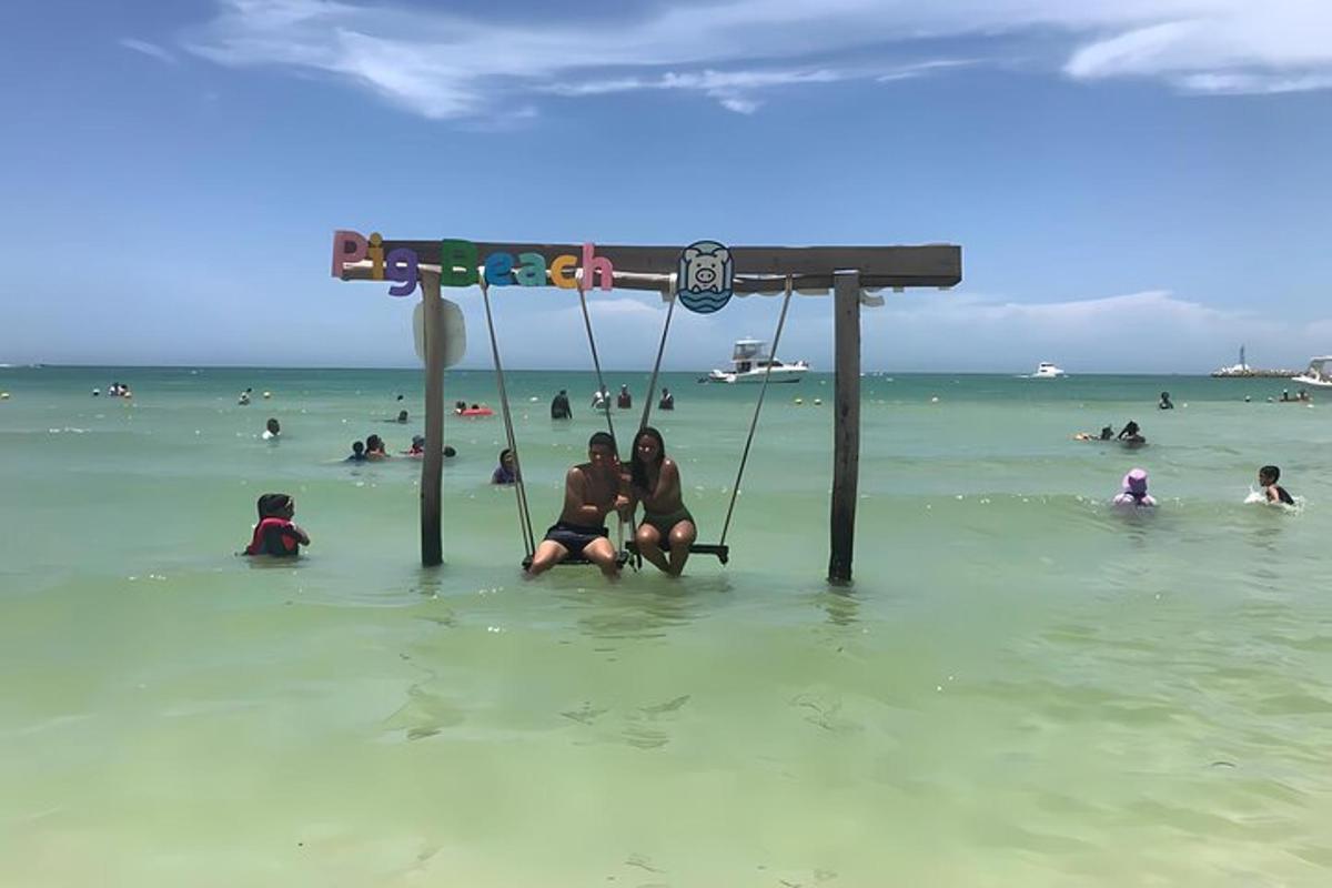 Dos mujeres sentadas en un columpio en el agua de la playa