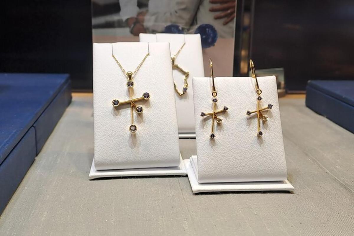tre orecchini e una collana a croce esposti in un negozio