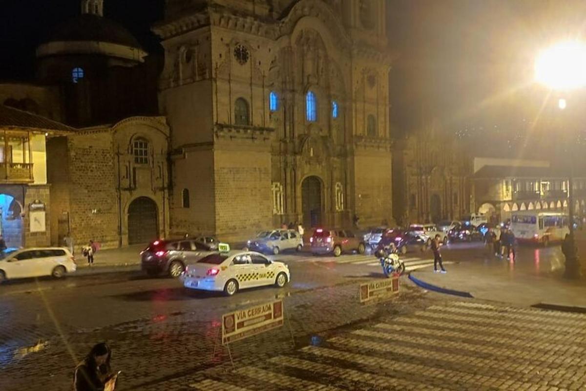 مجموعة من السيارات متوقفة أمام مبنى في الليل