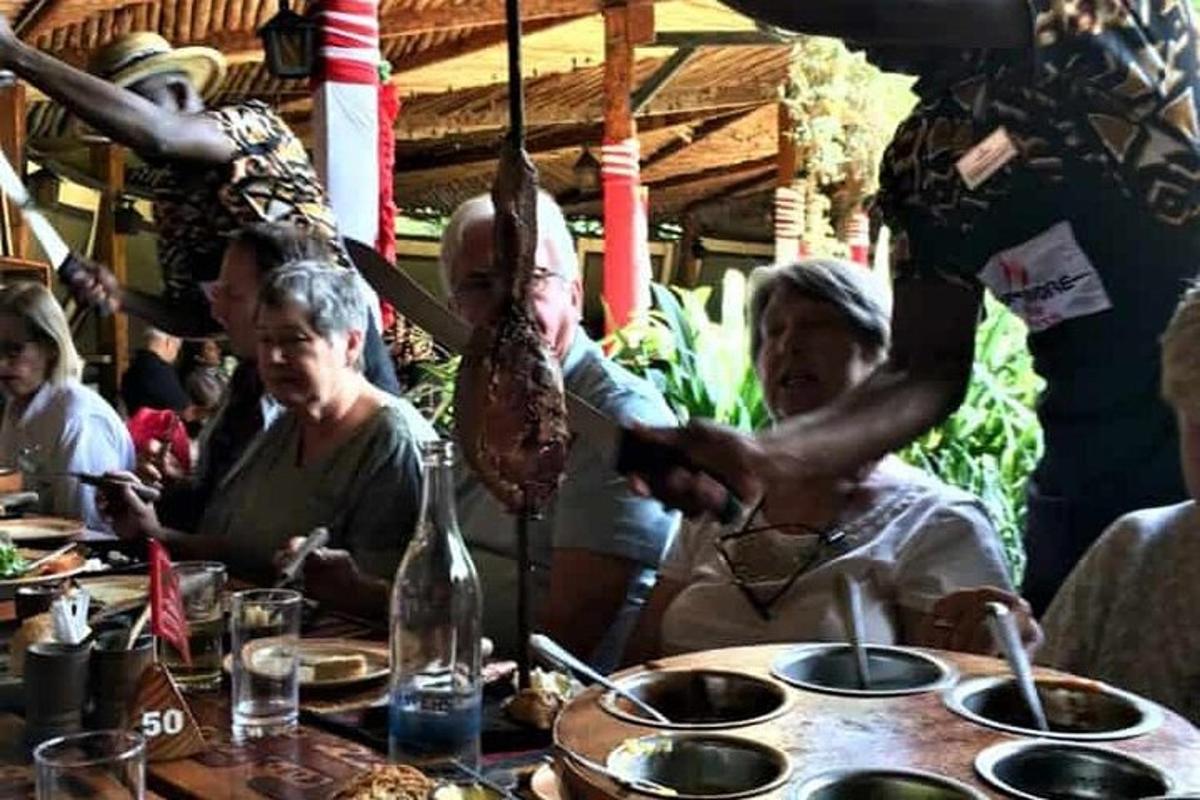 sekumpulan orang duduk di meja dengan makanan