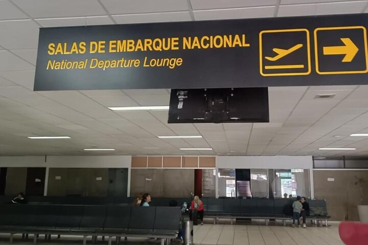 egy repülőtéri tábla, ahol az emberek a csomagjaikért várnak
