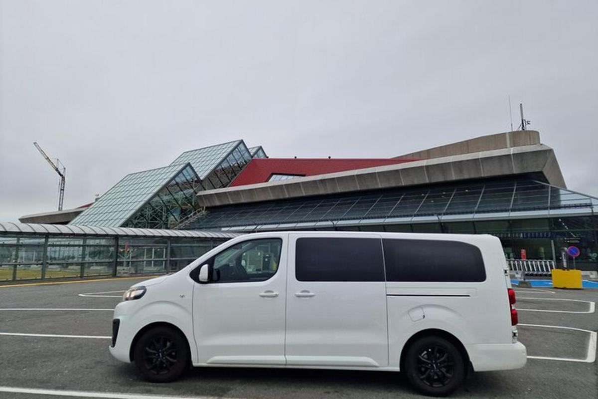 一辆白色货车停在一栋建筑前的停车场