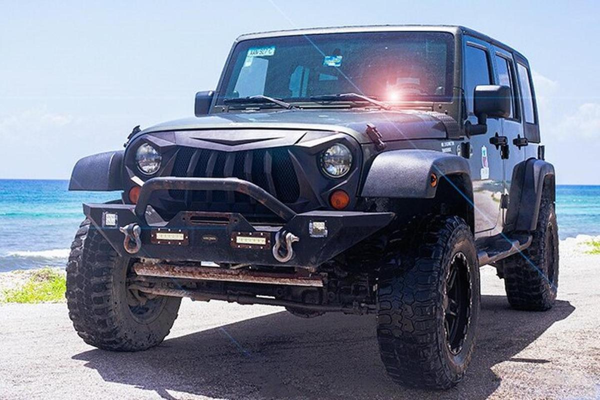 un jeep negro estacionado en la playa