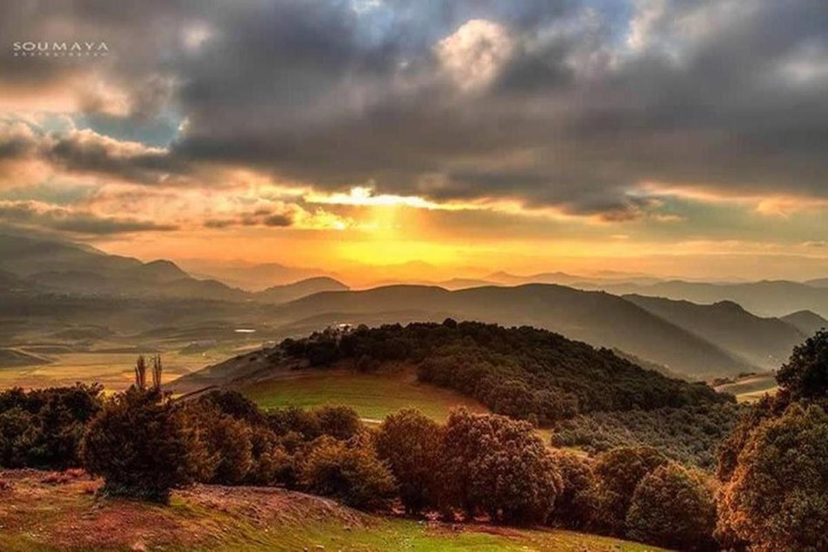 un tramonto su una catena montuosa con il sole che tramonta