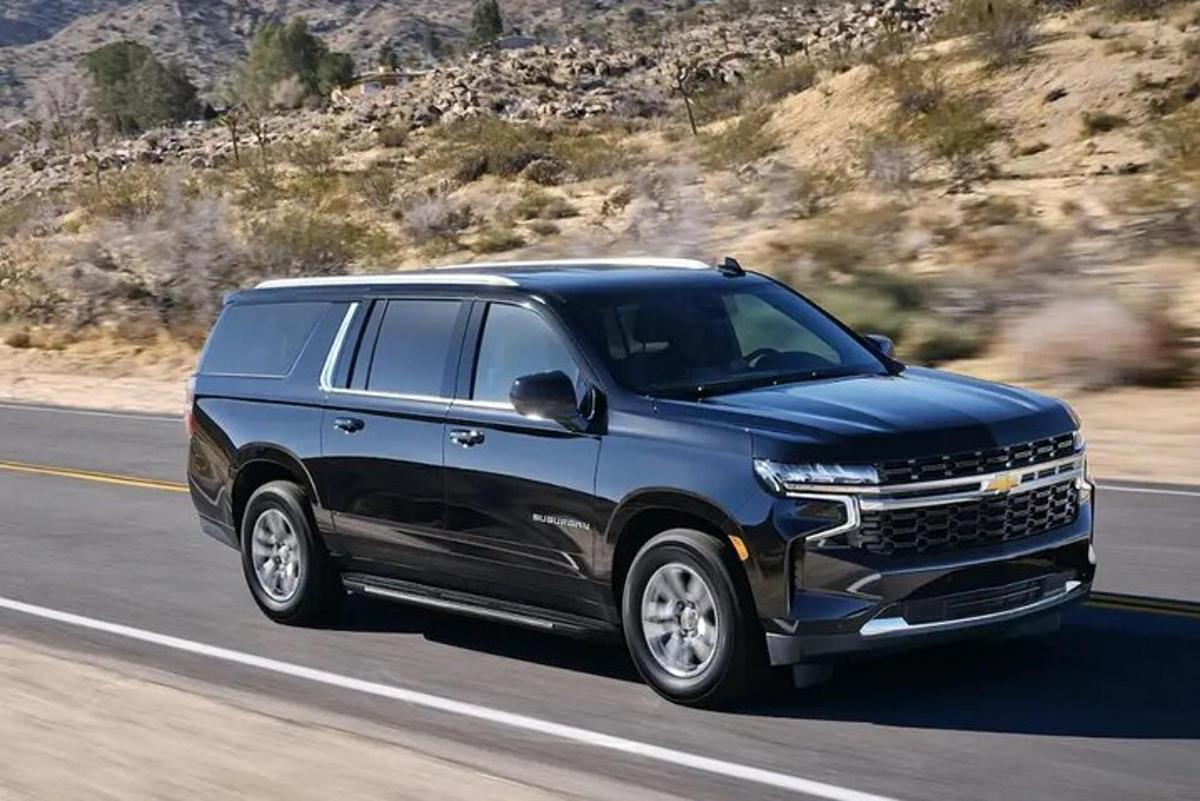 một chiếc suv màu xanh đang lái xe trên đường