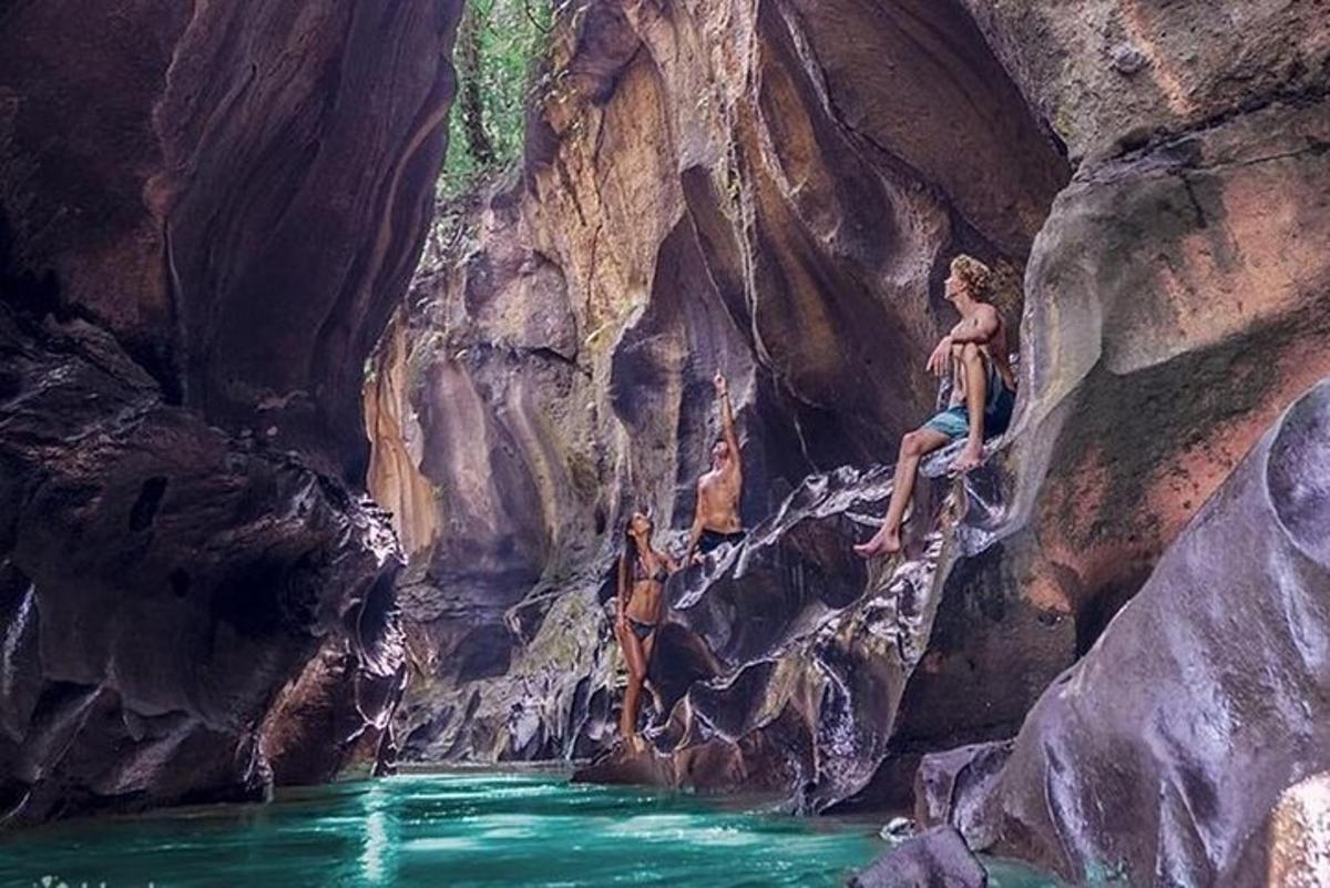 eine Gruppe von Menschen, die in einer Höhle in einen Fluss springen