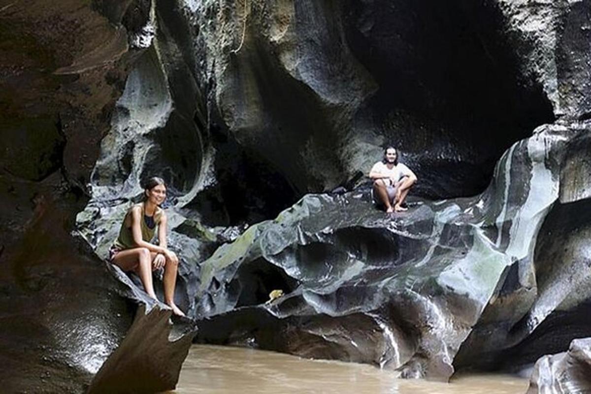 um homem e uma mulher sentados em uma pedra na água