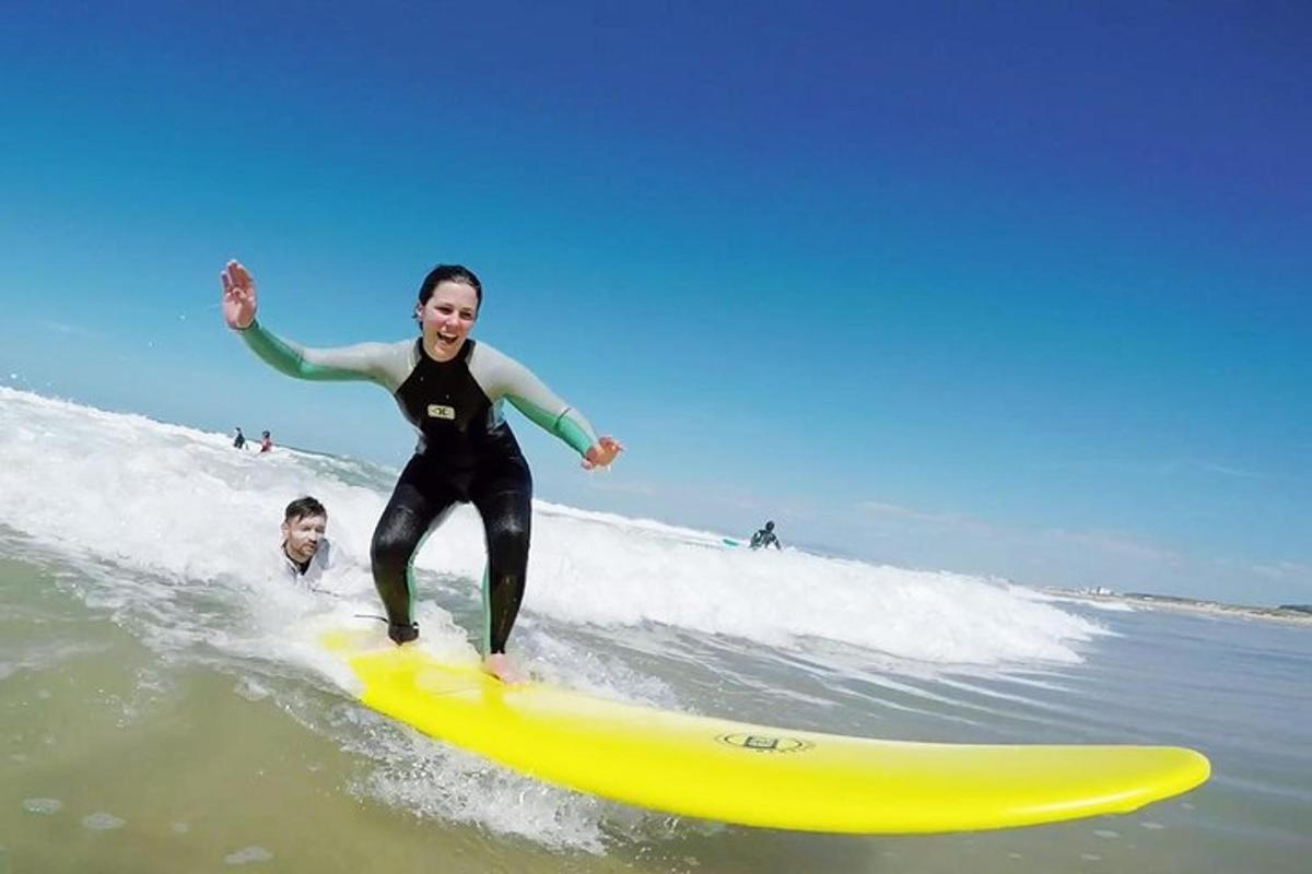 Una mujer montando una ola en una tabla de surf amarilla