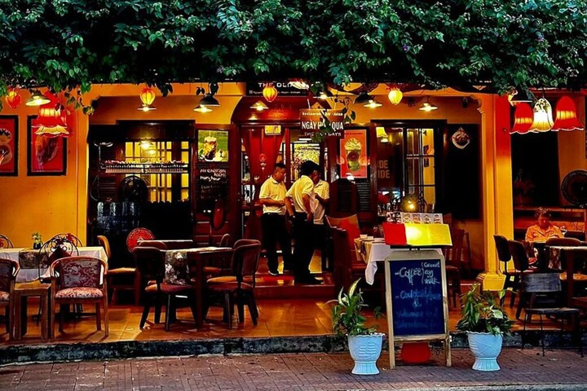 dos homes drets fora d'un restaurant amb taules i cadires