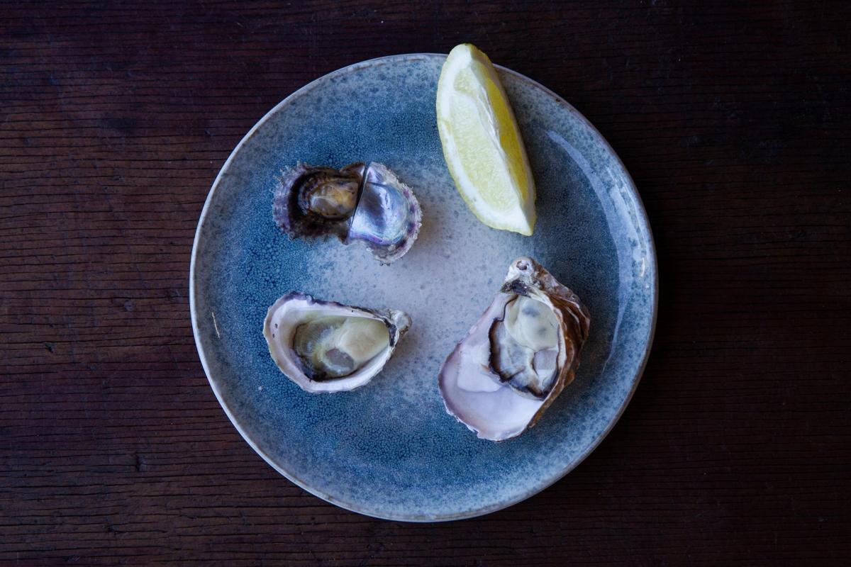 un plat amb tres ostres i una rodanxa de llima