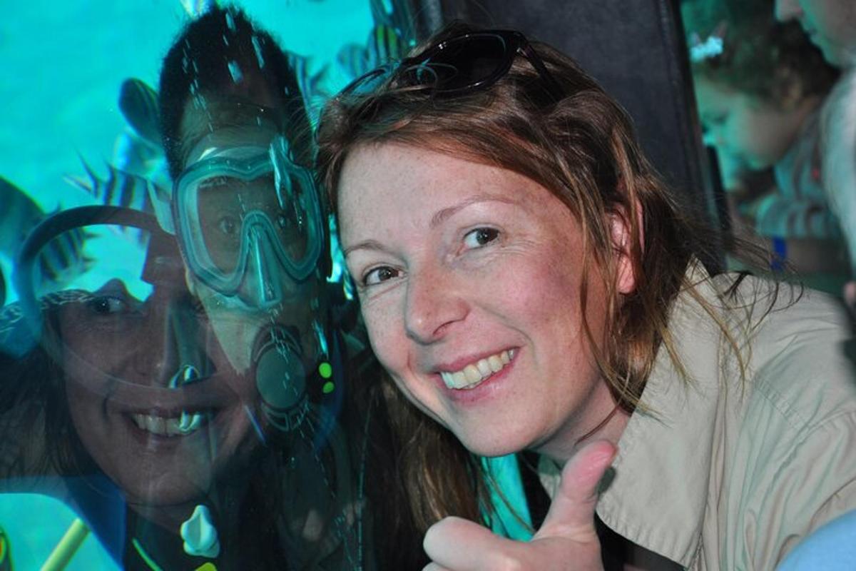 a woman giving a thumbs up in front of a glass window
