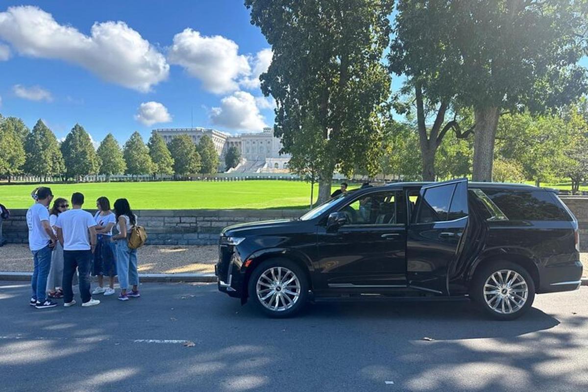 skupina lidí stojící vedle černého SUV