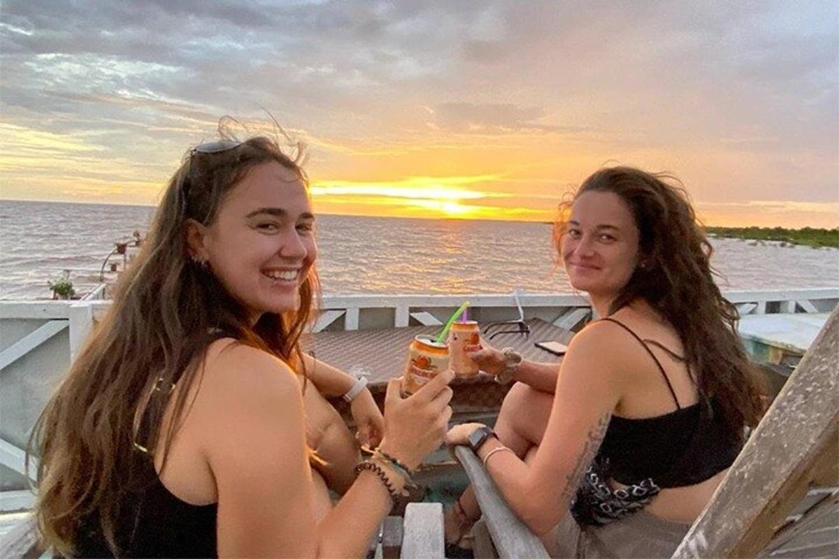 Dos mujeres sentadas en una mesa en un barco con bebidas.