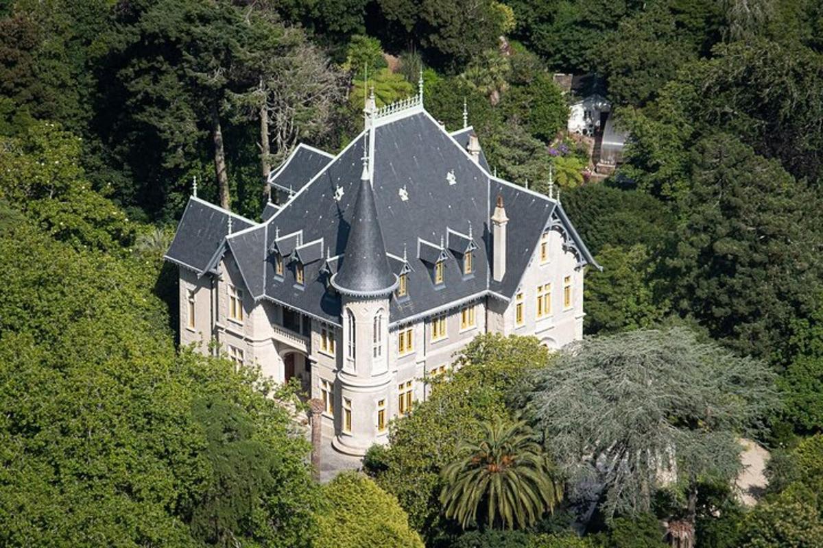 una grande casa bianca con il tetto nero su una collina