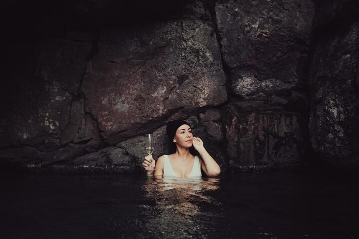 uma mulher na água segurando uma taça de vinho