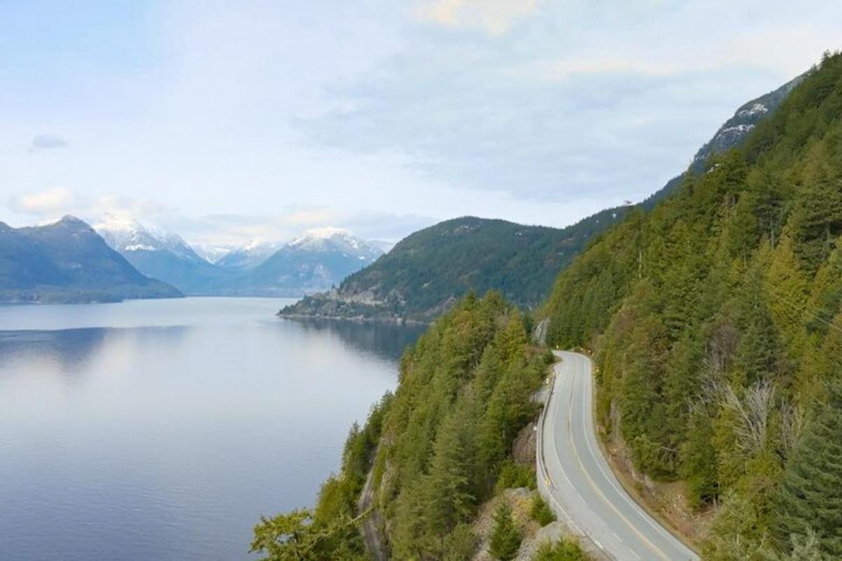 uma estrada na encosta de uma montanha próxima a um lago
