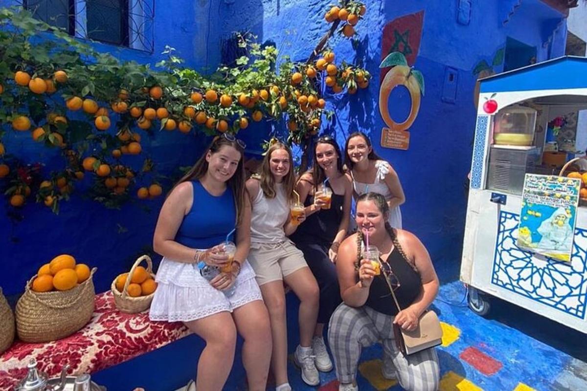 Un grupo de mujeres posando frente a una pared azul.