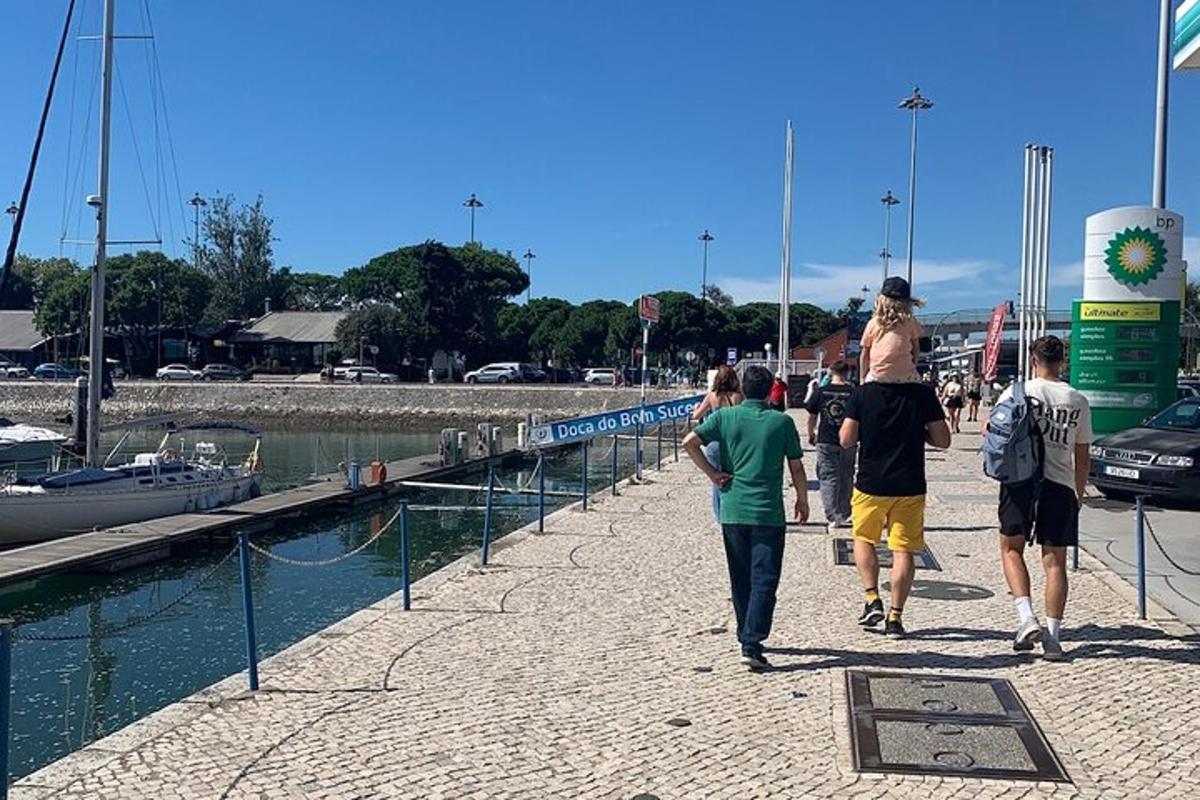 un gruppo di persone che camminano lungo un molo vicino a un porto turistico