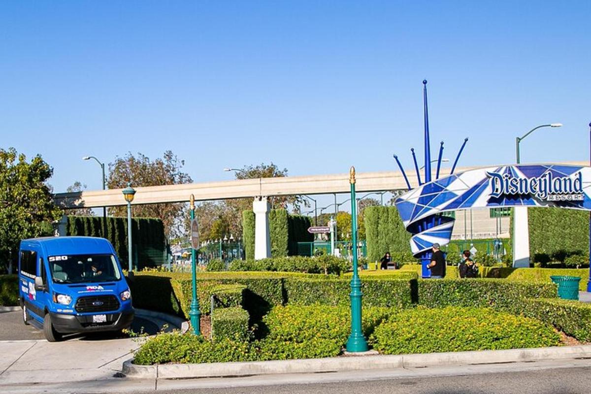 Egy kék teherautó parkolt egy parkolóban egy esernyővel