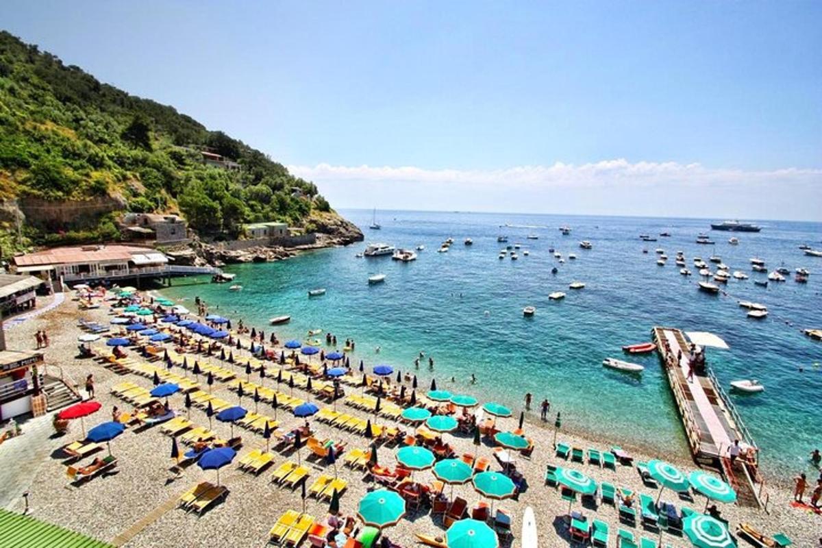 skupina ljudi na plaži s senčniki