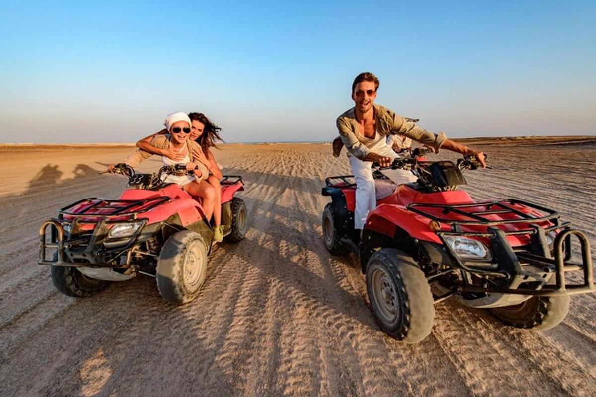 um homem e uma mulher andando de quadriciclo no deserto