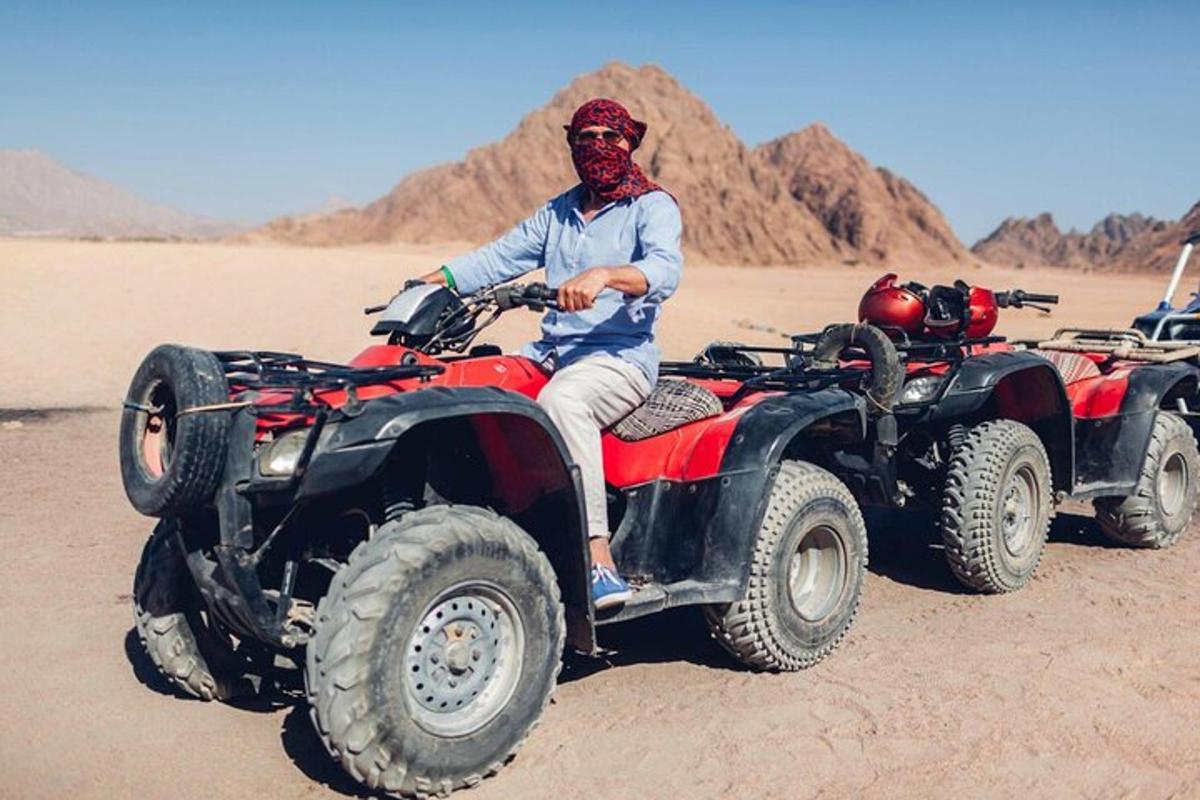 um homem sentado em um quadriciclo no deserto