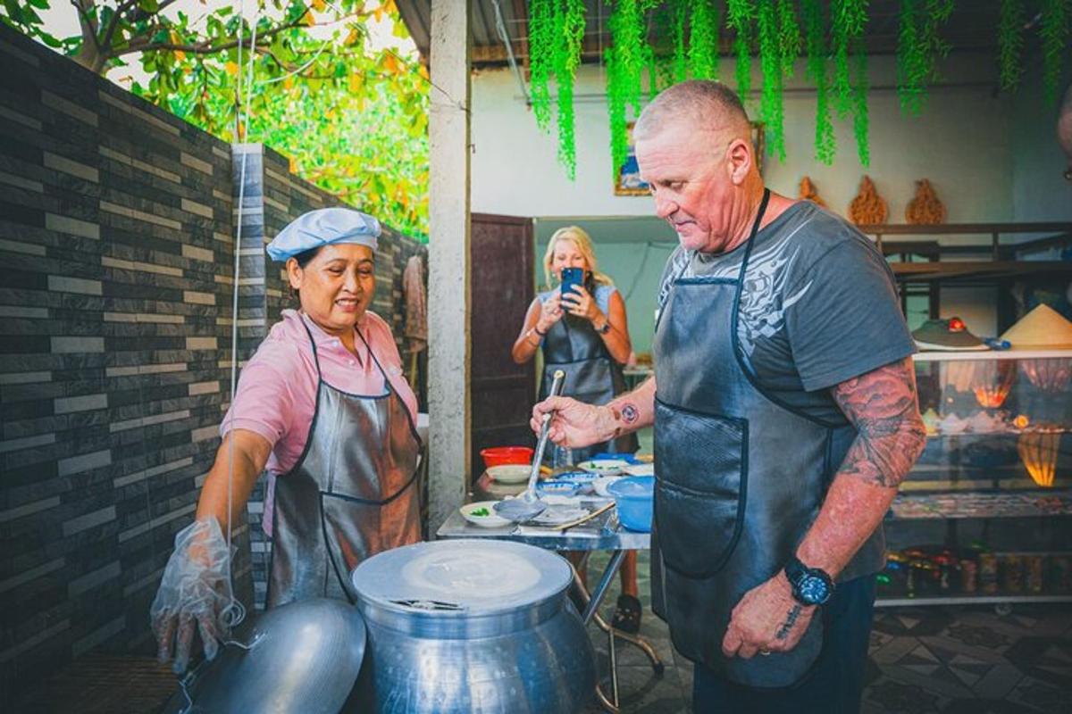 una donna che scatta una foto a un uomo in piedi accanto a una donna in cucina