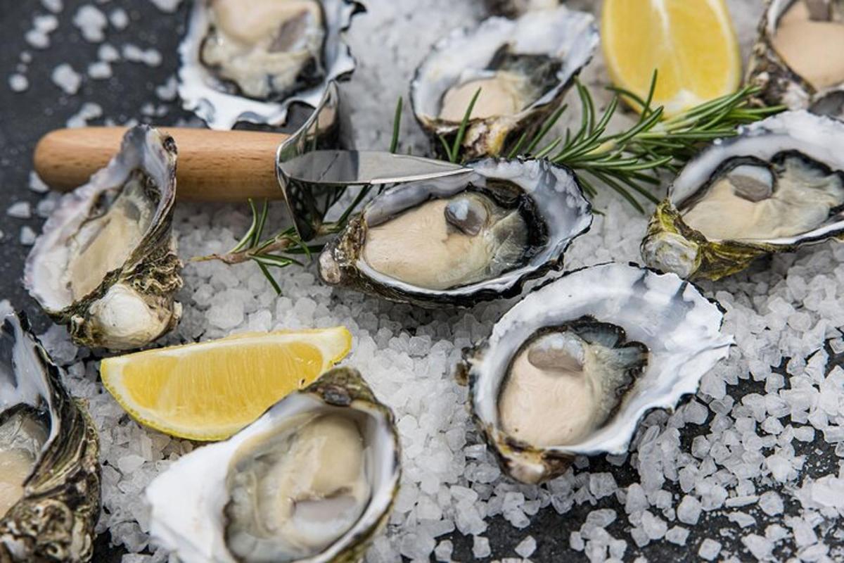 een groep oesters op ijs met een sigaar en citroen