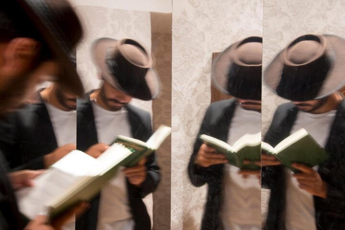 un hombre con sombrero leyendo un libro
