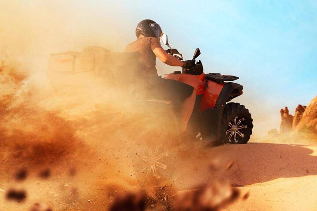 o persoană care merge pe un ATV în deșert