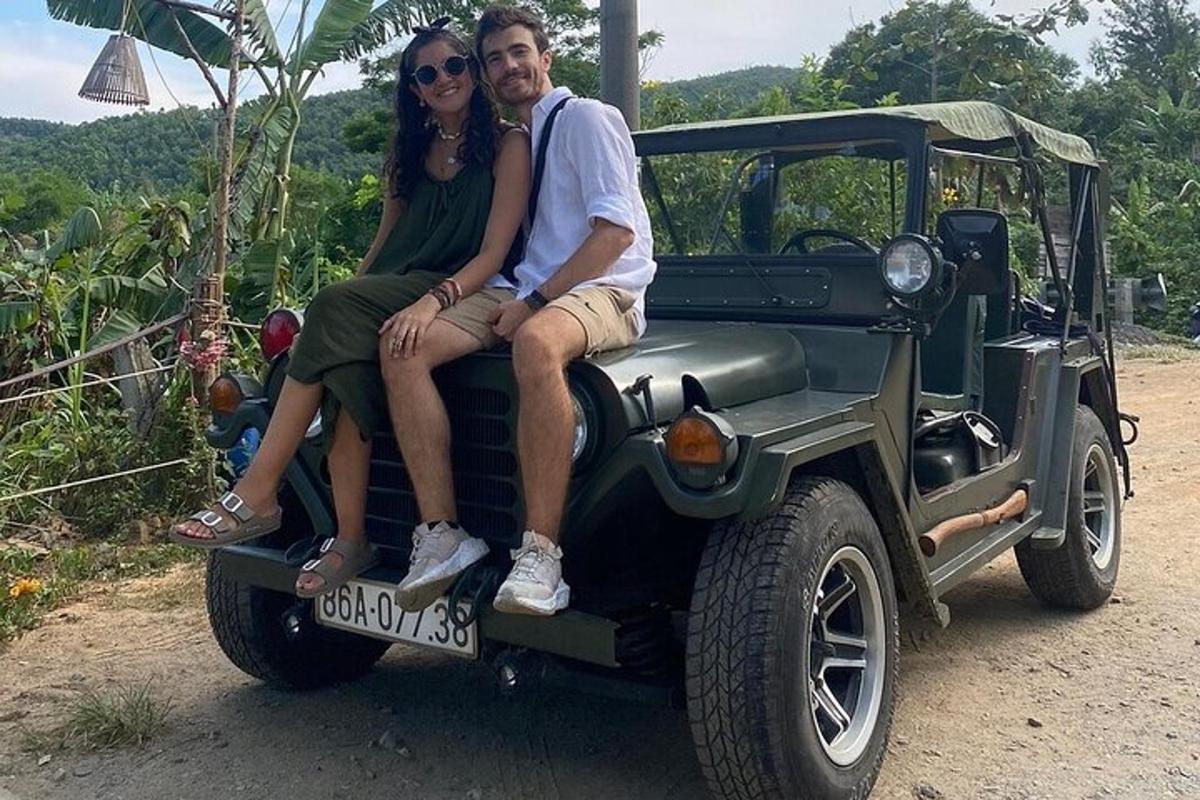 en mann og en kvinne som sitter på baksiden av en grønn jeep