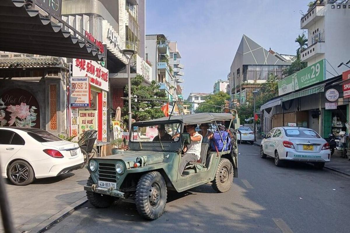 en grønn jeep som kjører nedover en bygate