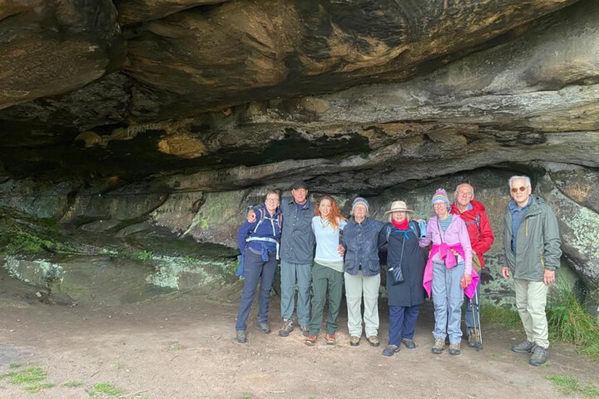 un gruppo di persone in piedi davanti a una grotta