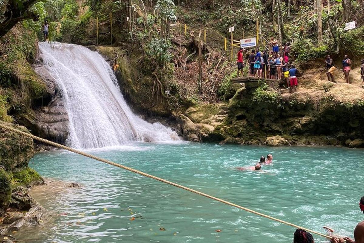 a group of people in a river with a waterfall